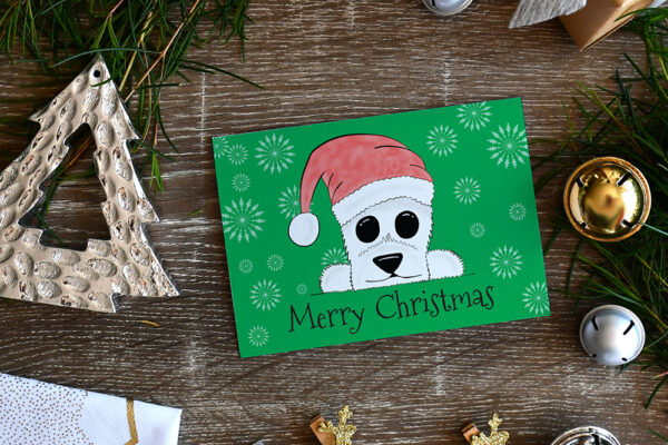 Green Christmas card featuring cartoon Westie in a Santa hat on a wood background surrounded by Christmas decorations and a small gift.