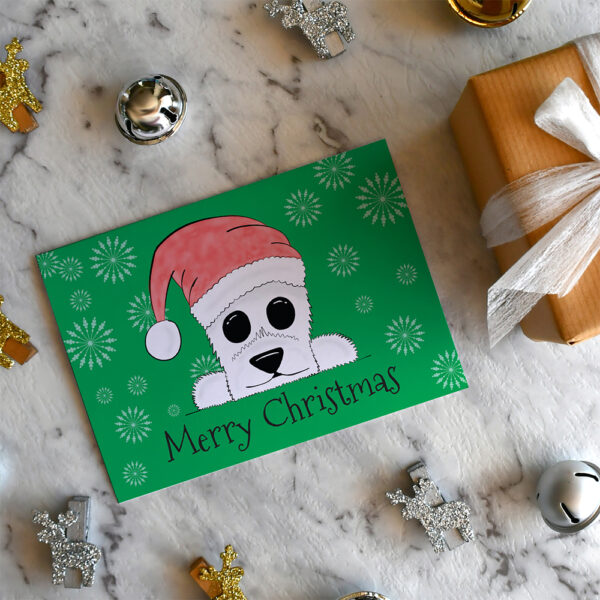 Green Christmas card featuring cartoon Westie in a Santa hat on a marble background surrounded by Christmas decorations and a small gift.