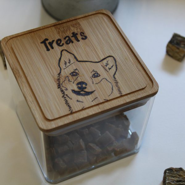 A plastic container with wooden lid with a shiba inu image burned into it